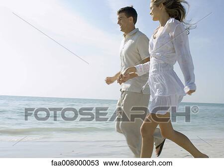 Couple running on beach View Large Photo Image Stock Image - Couple running on beach. Fotosearch