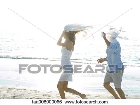 Couple running on beach View Large Photo Image Stock Photograph - Couple running on beach. Fotosearch