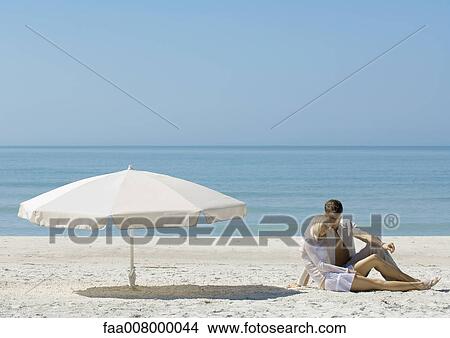 Couple sitting on beach View Large Photo Image Picture - Couple sitting on beach. Fotosearch