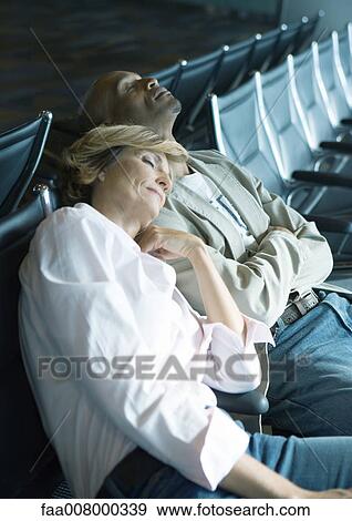 Couple sleeping in airport lounge View Large Photo Image Stock Photo - Couple sleeping in airport lounge. Fotosearch
