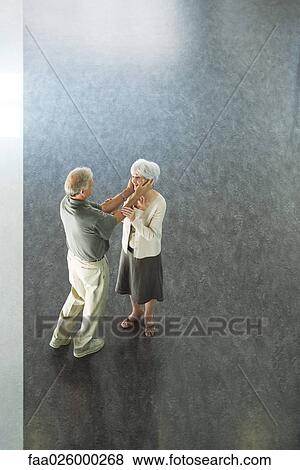 Couple standing face to face, man holding woman's face in hands, high angle view View Large Photo Image Stock Photo - Couple standing face to face, man holding woman's face in hands, high angle view. Fotosearch