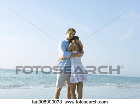 Couple standing on beach, embracing View Large Photo Image Stock Image - Couple standing on beach, embracing. Fotosearch