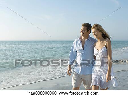 Couple walking on beach View Large Photo Image Stock Image - Couple walking on beach. Fotosearch