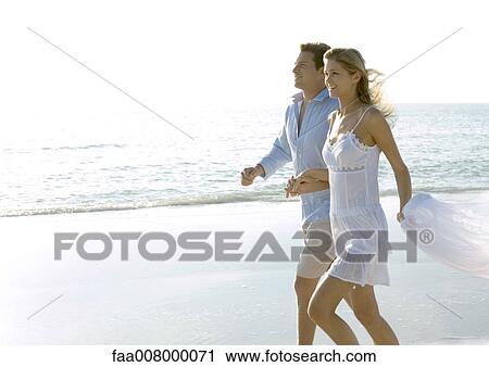Couple walking on beach View Large Photo Image Stock Image - Couple walking on beach. Fotosearch