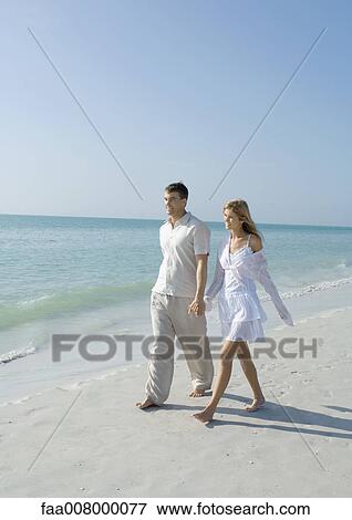 Couple walking on the beach View Large Photo Image Stock Photo - Couple walking on the beach. Fotosearch