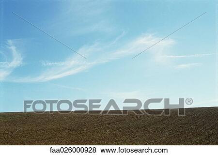 Cultivated field and blue sky View Large Photo Image Stock Photo - Cultivated field and blue sky. Fotosearch
