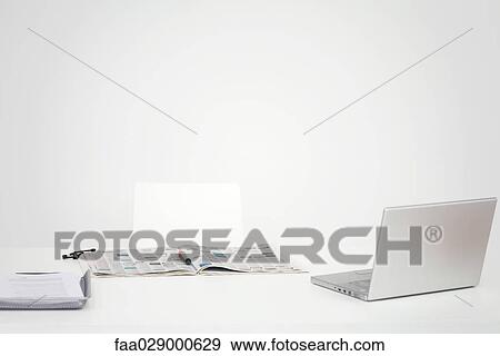 Desk with laptop computer and open newspaper with circled listings View Large Photo Image Stock Photo - Desk with laptop computer and open newspaper with circled listings. Fotosearch