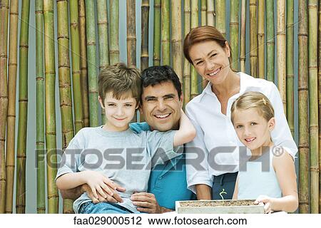 Family smiling together in front of bamboo, group portrait View Large Photo Image Stock Image - Family smiling together in front of bamboo, group portrait. Fotosearch