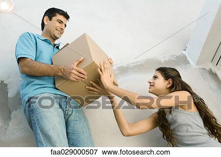Father and daughter moving cardboard box together, low angle view View Large Photo Image Stock Photo - Father and daughter moving cardboard box together, low angle view. Fotosearch
