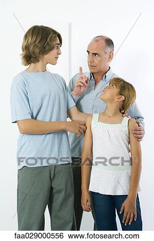 Father shaking his finger at teen son, preteen daughter watching and smiling View Large Photo Image Stock Photograph - Father shaking his finger at teen son, preteen daughter watching and smiling. Fotosearch