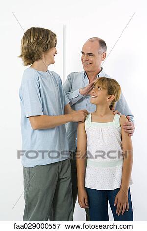 Father standing with teen son and preteen daughter, all smiling at each other View Large Photo Image Stock Photo - Father standing with teen son and preteen daughter, all smiling at each other. Fotosearch