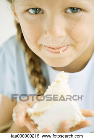 Stock Photograph - Girl eating cake. Fotosearch