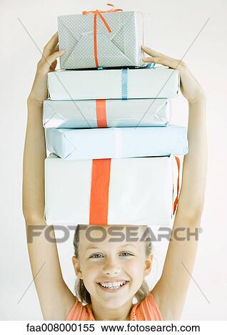 Girl holding stack of presents on head View Large Photo Image Stock Photography - Girl holding stack of presents on head. Fotosearch