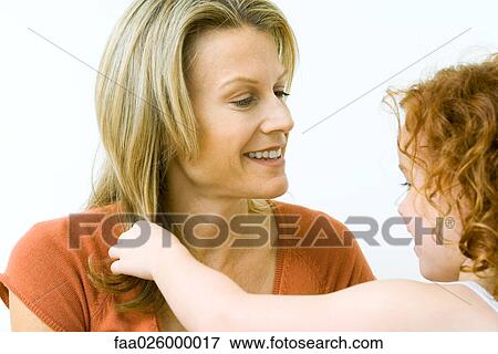 Girl touching her mother's hair, both smiling, close-up View Large Photo Image Stock Photo - Girl touching her mother's hair, both smiling, close-up. Fotosearch