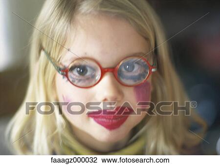 Stock Image - Girl wearing make-up and glasses. Fotosearch