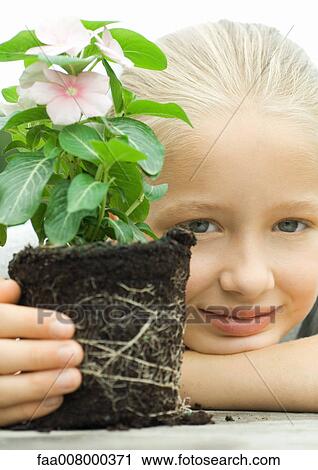 Girl with unpotted plant, smiling View Large Photo Image Stock Image - Girl with unpotted plant, smiling. Fotosearch