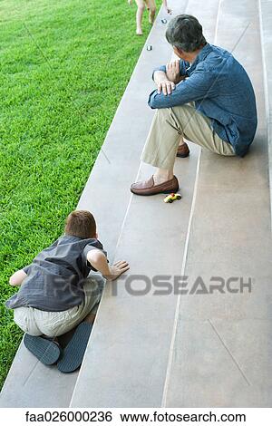 Grandfather and grandchildren sitting on steps, playing with toy cars, high angle view View Large Photo Image Stock Photograph - Grandfather and grandchildren sitting on steps, playing with toy cars, high angle view. Fotosearch