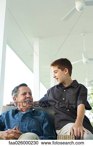 Grandfather and grandson sitting together on porch, both smiling View Large Photo Image Stock Image - Grandfather and grandson sitting together on porch, both smiling. Fotosearch