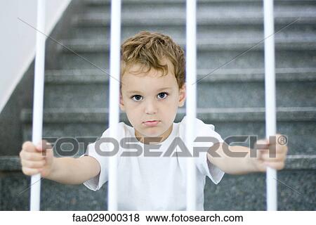 Little boy behind bars, looking at camera View Large Photo Image Stock Photo - Little boy behind bars, looking at camera. Fotosearch