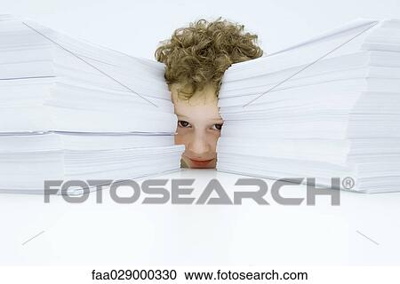 Little boy behind two large stacks of paper, peeking at camera View Large Photo Image Stock Image - Little boy behind two large stacks of paper, peeking at camera. Fotosearch