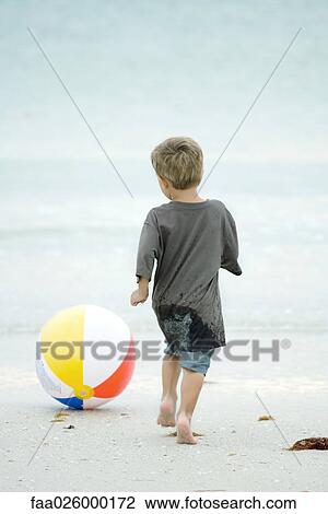 Little boy chasing beach ball at the beach, rear view View Large Photo Image Stock Image - Little boy chasing beach ball at the beach, rear view. Fotosearch