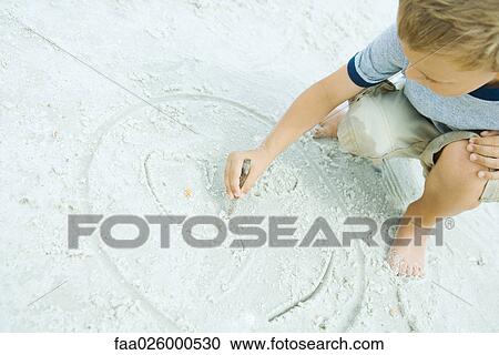 Little boy crouching at the beach, drawing in sand with stick, tilted view View Large Photo Image Stock Image - Little boy crouching at the beach, drawing in sand with stick, tilted view. Fotosearch