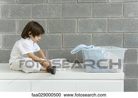 Little boy folding laundry, side view View Large Photo Image Stock Image - Little boy folding laundry, side view. Fotosearch