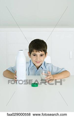 Little boy holding bottle of milk and empty glass, smiling at camera View Large Photo Image Stock Photo - Little boy holding bottle of milk and empty glass, smiling at camera. Fotosearch