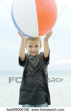 Little boy holding up beach ball, smiling, close-up View Large Photo Image Stock Image - Little boy holding up beach ball, smiling, close-up. Fotosearch