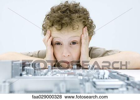 Little boy looking at circuit board, holding head, raising eyebrows View Large Photo Image Stock Photo - Little boy looking at circuit board, holding head, raising eyebrows. Fotosearch