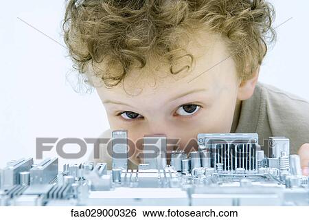 Little boy looking over circuit board at camera, close-up View Large Photo Image Stock Photograph - Little boy looking over circuit board at camera, close-up. Fotosearch