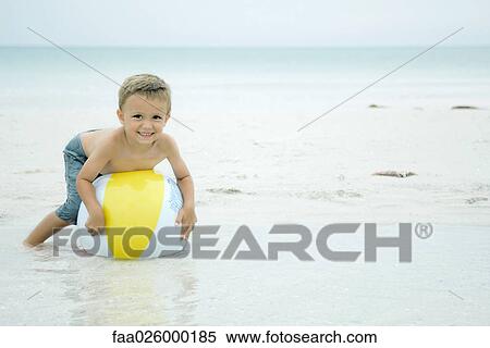 Little boy lying on top of beach ball at the beach, smiling at camera View Large Photo Image Stock Photography - Little boy lying on top of beach ball at the beach, smiling at camera. Fotosearch