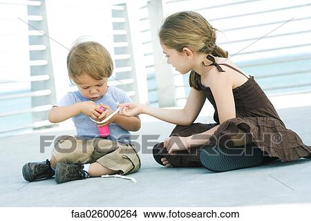 Little girl helping younger brother inflate balloon with air pump View Large Photo Image Picture - Little girl helping younger brother inflate balloon with air pump. Fotosearch