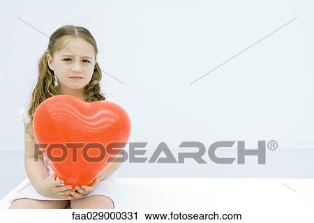Little girl holding hear shaped balloon, looking at camera, portrait View Large Photo Image Stock Image - Little girl holding hear shaped balloon, looking at camera, portrait. Fotosearch