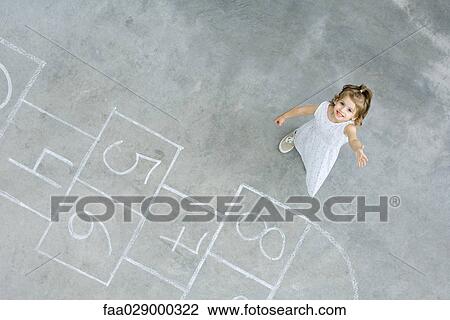 Little girl standing next to hopscotch squares, smiling up at camera, high angle view View Large Photo Image Stock Image - Little girl standing next to hopscotch squares, smiling up at camera, high angle view. Fotosearch