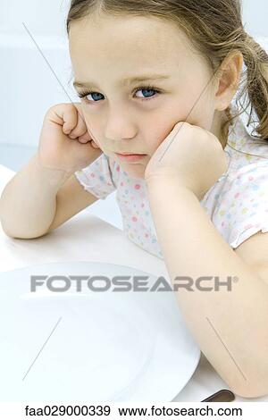 Little girl sulking at dinner table, close-up View Large Photo Image Stock Photo - Little girl sulking at dinner table, close-up. Fotosearch