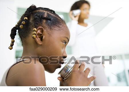 Little girl talking into tin can phone, mother listening in background, low angle view View Large Photo Image Stock Photo - Little girl talking into tin can phone, mother listening in background, low angle view. Fotosearch