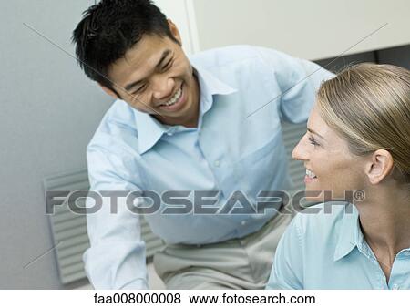 Male and female colleagues smiling at each other View Large Photo Image Stock Photo - Male and female colleagues smiling at each other. Fotosearch