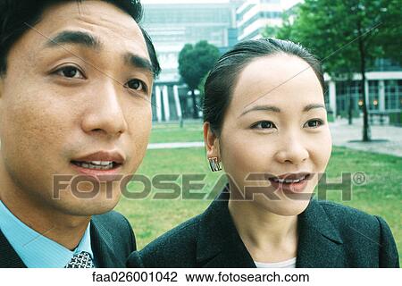 Male and female professionals side by side, smiling, looking away, close-up View Large Photo Image Stock Image - Male and female professionals side by side, smiling, looking away, close-up. Fotosearch