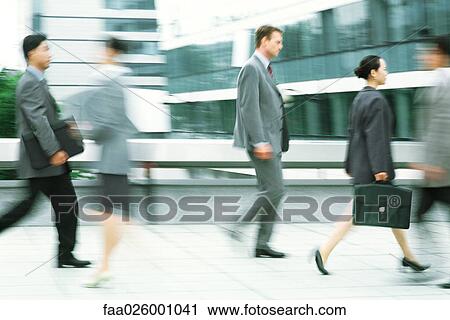 Male and female professionals walking on sidewalk, blurred motion View Large Photo Image Stock Image - Male and female professionals walking on sidewalk, blurred motion. Fotosearch
