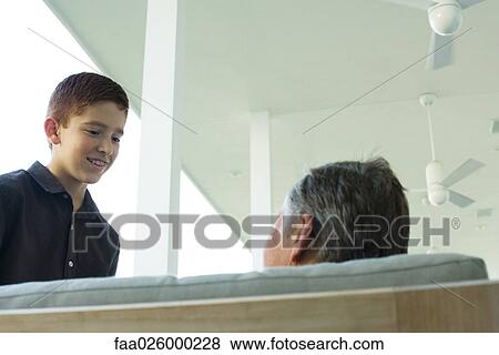 Man and boy face to face on porch, smiling at each other, low angle view View Large Photo Image Stock Photo - Man and boy face to face on porch, smiling at each other, low angle view. Fotosearch