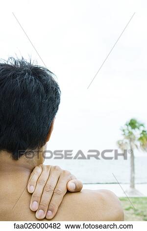 Man at the beach, hand on shoulder, cropped rear view View Large Photo Image Stock Image - Man at the beach, hand on shoulder, cropped rear view. Fotosearch