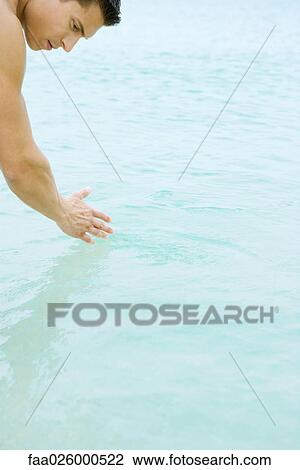 Man bending over, touching water, cropped view View Large Photo Image Stock Image - Man bending over, touching water, cropped view. Fotosearch