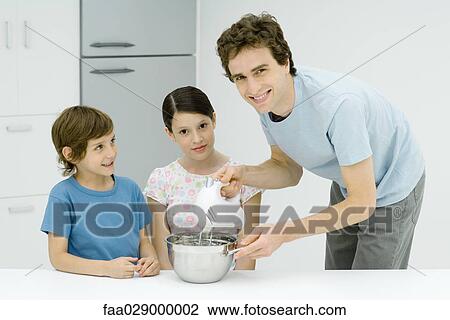 Man cooking with girl and boy, smiling at camera View Large Photo Image Stock Image - Man cooking with girl and boy, smiling at camera. Fotosearch