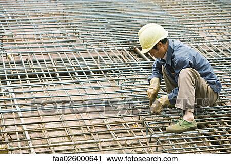 Man crouching at construction site, building steel framework View Large Photo Image Stock Image - Man crouching at construction site, building steel framework. Fotosearch