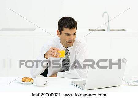 Man having breakfast and using laptop View Large Photo Image Stock Image - Man having breakfast and using laptop. Fotosearch