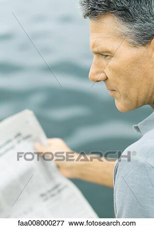 Man holding newspaper, looking away View Large Photo Image Stock Photo - Man holding newspaper, looking away. Fotosearch