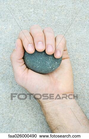 Man holding pebble in hand, cropped view View Large Photo Image Stock Image - Man holding pebble in hand, cropped view. Fotosearch