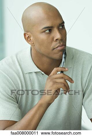Man holding pen to chin, portrait View Large Photo Image Stock Image - Man holding pen to chin, portrait. Fotosearch