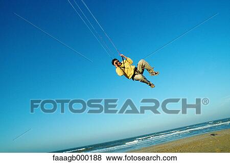Man in mid air, kitesurfing View Large Photo Image Stock Photo - Man in mid air, kitesurfing. Fotosearch